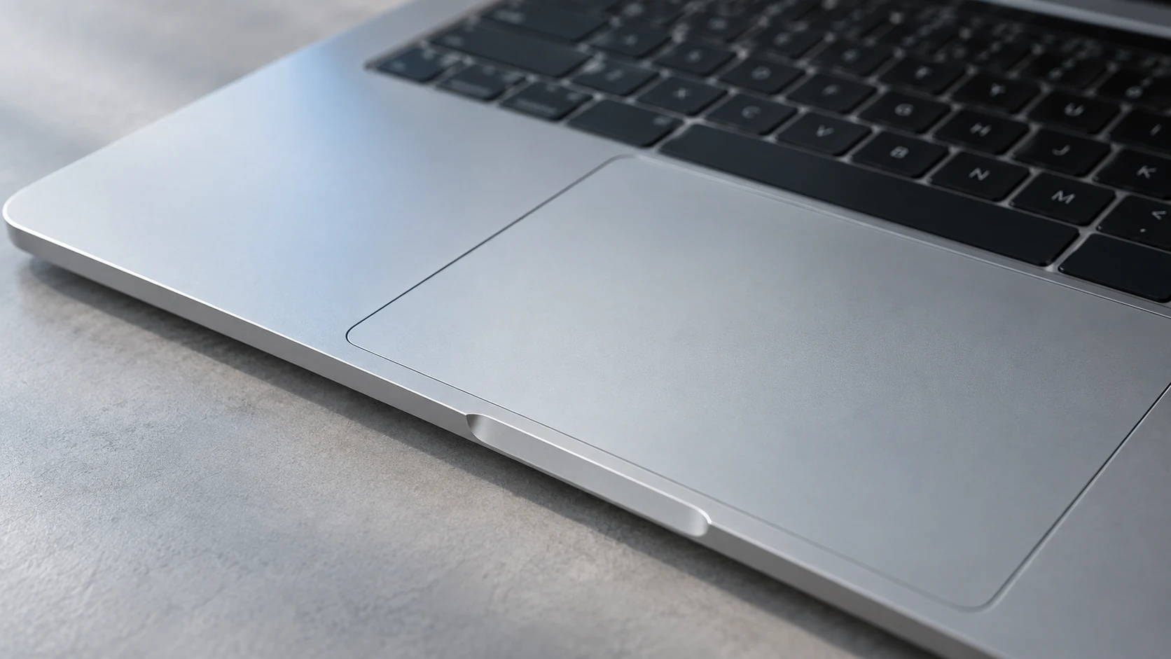 A close-up of the keyboard and trackpad on a silver laptop